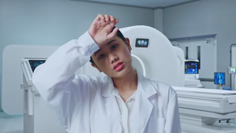 Close Up Of Tired Asian Woman Doctor Standing With Mri Machine In The Hospital