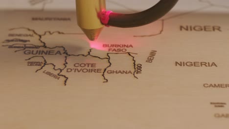 cnc laser cutting machine cuts world map on wooden plank and plywood