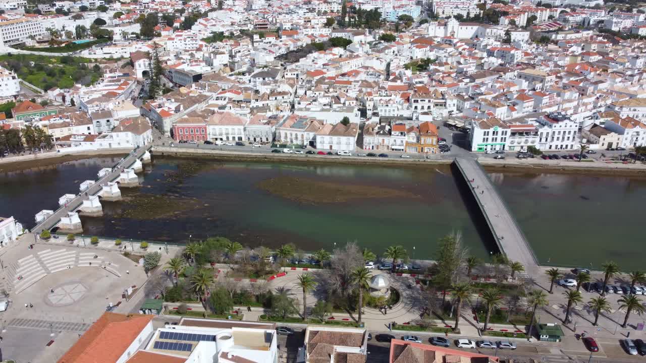Vuelo de dron sobre Tavira, Algarve, Portugal, la plaza del casco antiguo y el río, un día cálido y soleado a principios de primavera, una toma panorámica del centro de la ciudad.