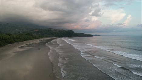 Toma-Aérea-Siguiendo-La-Costa-Costarricense-Con-Olas-Rompiendo-Durante-El-Atardecer.