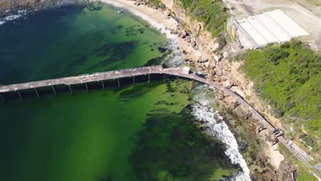 Drohnenschwenkblick-über-Den-Brückenstrand-Der-Bergbaustadt-Und-Den-Kohlenkai-Im-Pazifischen-Ozean-Von-Catherine-Hill-Bay-Swansea-Newcastle-NSW-Australien-3840x2160-4k