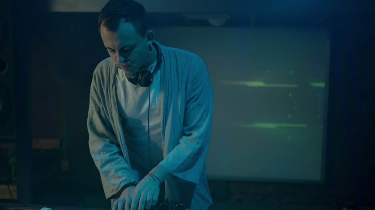 dj de baile compone una nueva mezcla de música bajo la iluminación del club