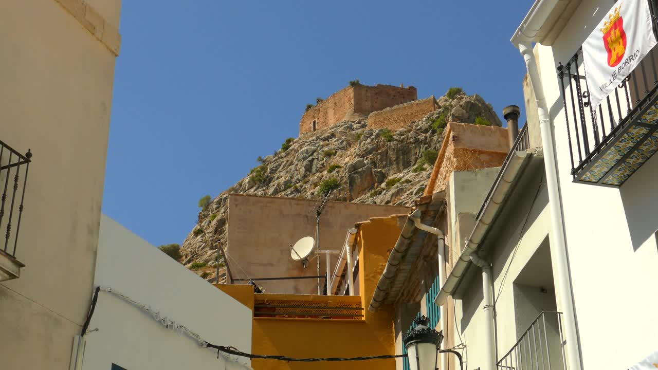 una vista de una ciudad histórica con un castillo encaramado en una montaña cercana en borriol, españa - de cerca