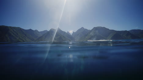 glistening view of tahitian mountain valleys on sunny day from teahupoo surf break