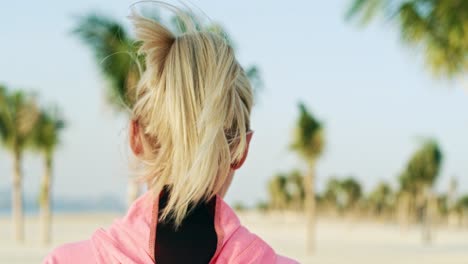 handheld video shows of female athlete jogging on the beach