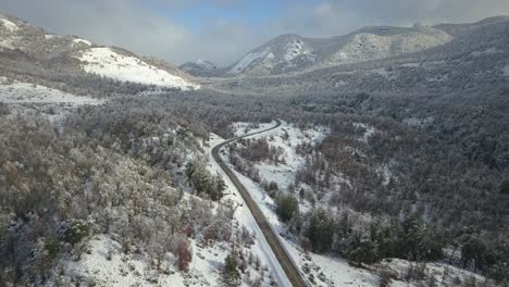 Vista-De-Drones-De-Un-Valle-Completamente-Nevado-Que-Es-Atravesado-Por-Una-Carretera