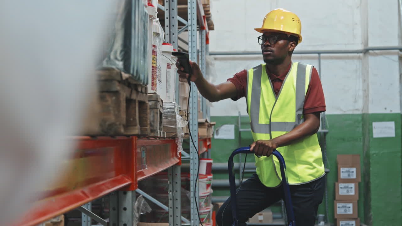 Black Male Worker Scanning Barcodes in Warehouse