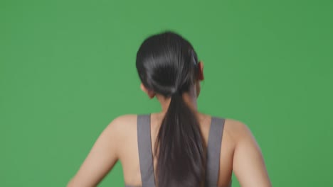 woman in grey sports bra, back view on green screen