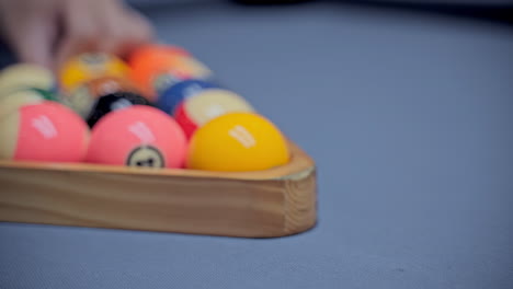 billiard player hands with gloves moves and levels the pyramid of balls foward