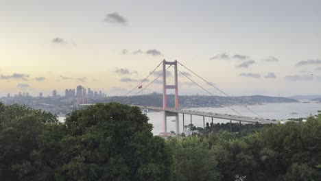 istanbul bosphorus bridge at golden hour, soft pastel sky glows as traffic rushes across