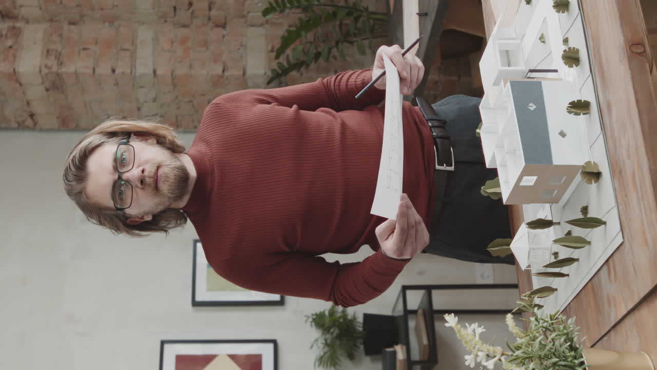 Serious Male Architect Working With House Layout