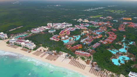 bird's eye view of the massive beachfront hotel and tourism industry building complexes on the playa paraiso beach in tulum, mexico