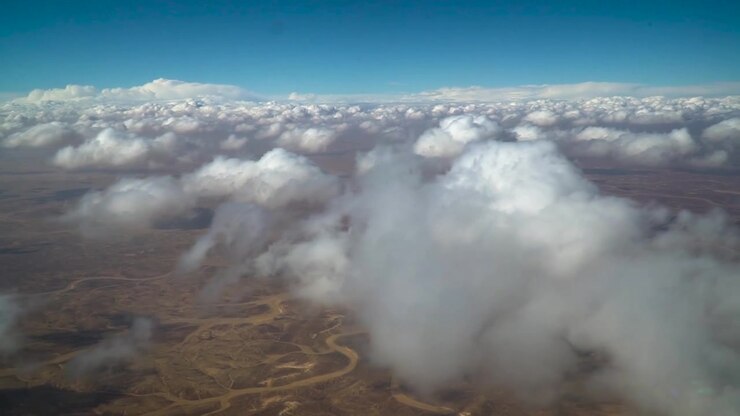 Stunning aerial footage captured by aircraft flying over barren terrain in Jordan. Features rugged desert landscapes, dry valleys, and rocky formations under warm natural light.