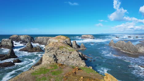 stunning 4k aerial drone shot gliding over ocean rocks with seagulls flying away in bandon, oregon