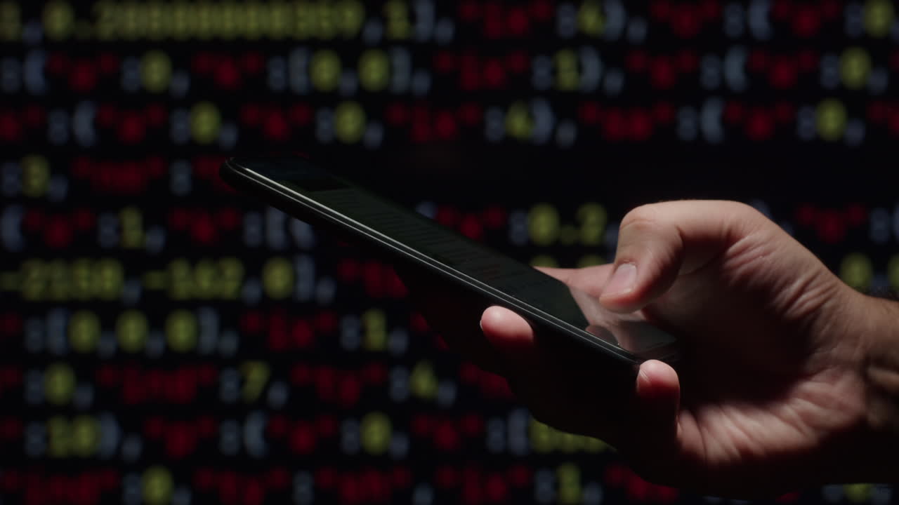 mano usando el teléfono inteligente en un fondo oscuro con visualización de datos