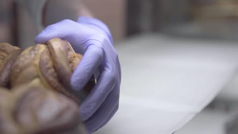coffee shop worker placing delicious bread on a bakery stand