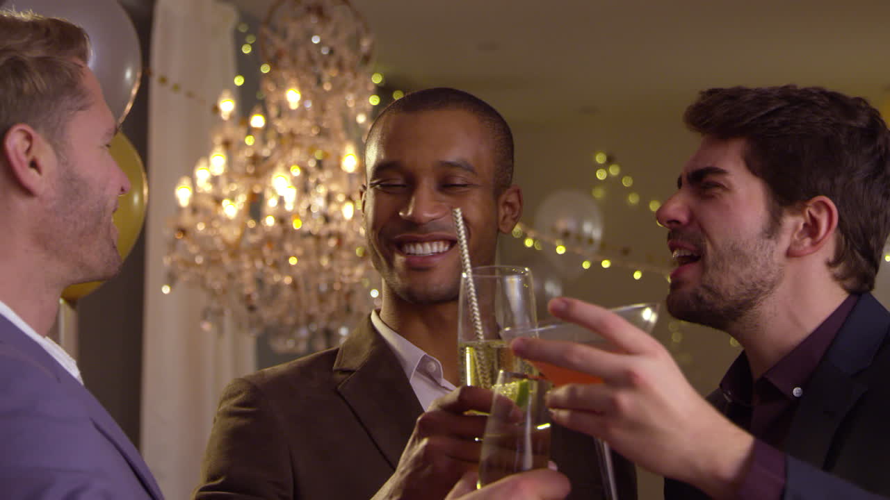 Male Friends Make Toast As They Celebrate At Party Together
