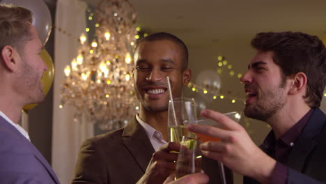 amigos masculinos hacen un brindis mientras celebran en una fiesta juntos