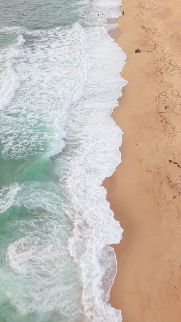 The beach's patterns of surf lines and pathways emerge clearly in this vertical look at Fort Ord Beach Marina