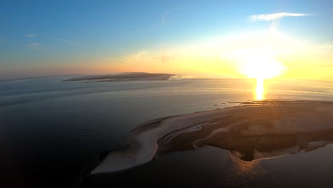 imágenes aéreas de drones a vista de pájaro de izquierda a derecha volando alrededor de las islas del norte de alemania al atardecer junto al mar