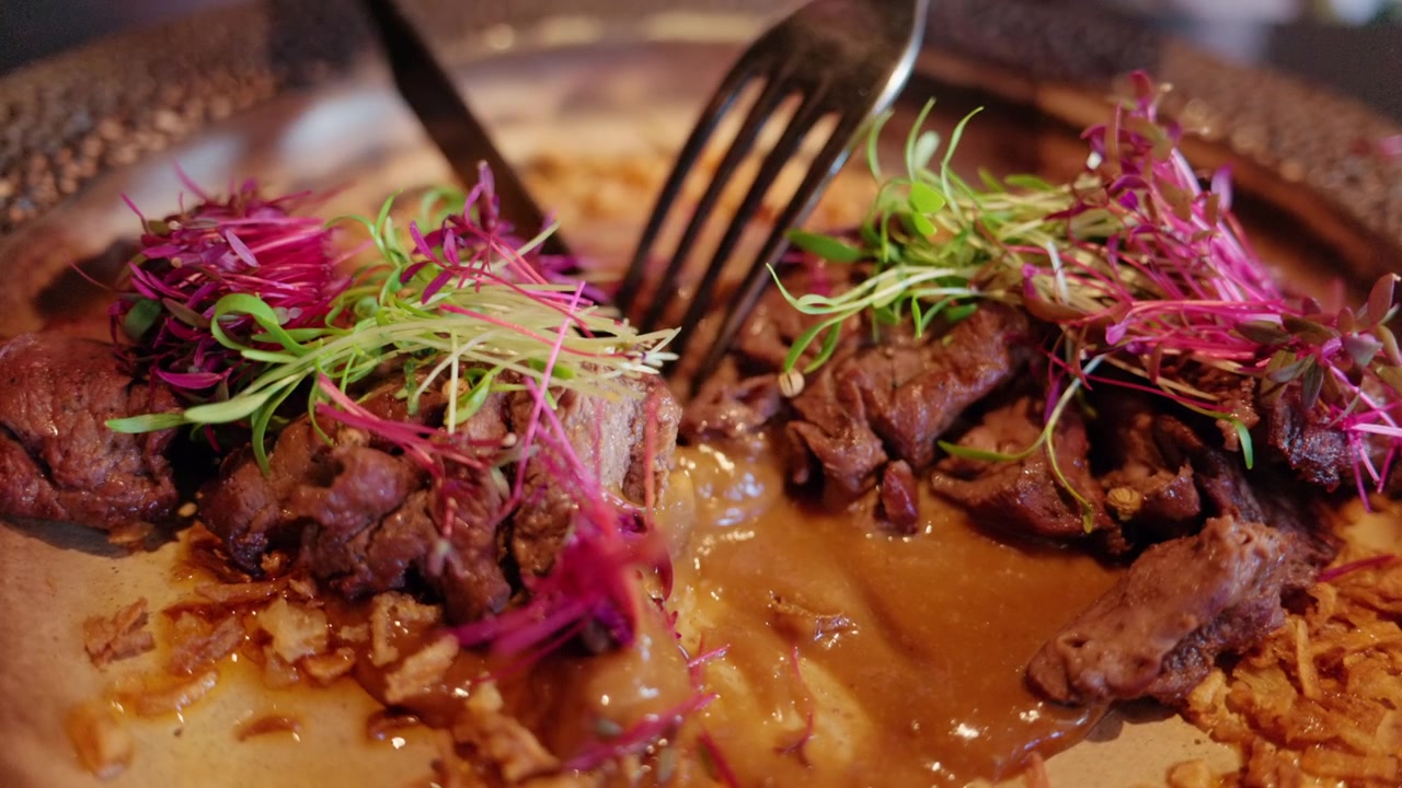 Close up of gourmet meat dish with sauce and microgreens