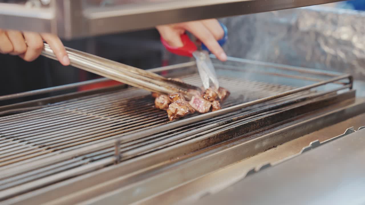 Close up of a Taiwanese street food vendor expertly flame-torching juicy beef cubes, capturing the fiery preparation and mouthwatering appeal of this popular night market delicacy