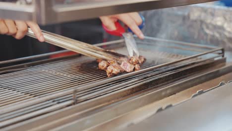 close up of a taiwanese street food vendor expertly flame-torching juicy beef cubes, capturing the fiery preparation and mouthwatering appeal of this popular night market delicacy