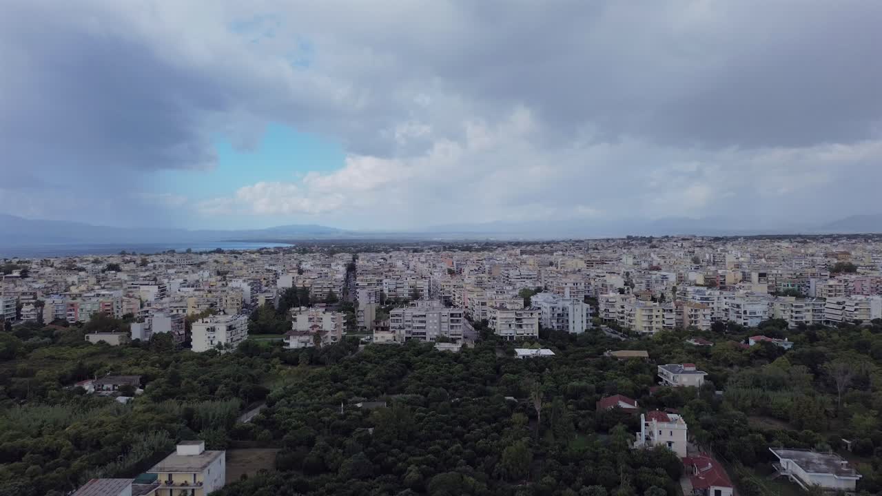 Cityscape aerial view of Kalamata city on a cloudy autumn day, orchards on foreground, cloudy skies on background 4K