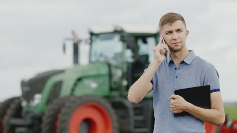 a young successful farmer communicates by phone