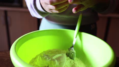 cook preparing dough for bread, puts the eggs into flour - high angle, close up