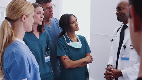 multi-cultural medical team having meeting in hospital corridor