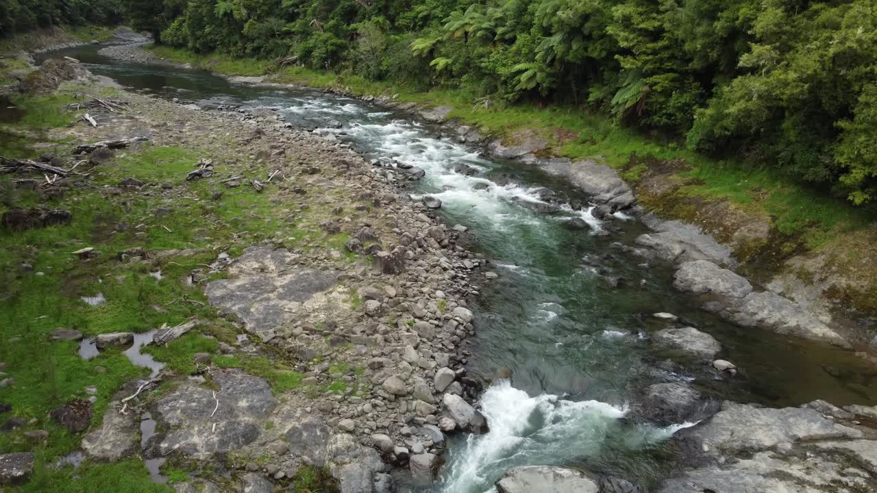 Vista aerea di un fiume montano limpido e incontaminato che scorre attraverso la foresta su rapide.