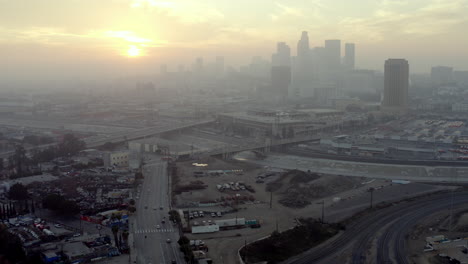 aerial drone rising above city traffic during sunset in downtown los angeles