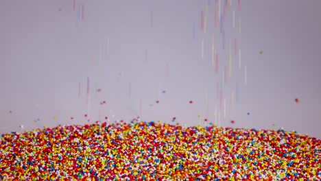 vibrant sprinkles cascade onto a pile, creating a colorful, dynamic visual against a neutral background. captured in slow motion