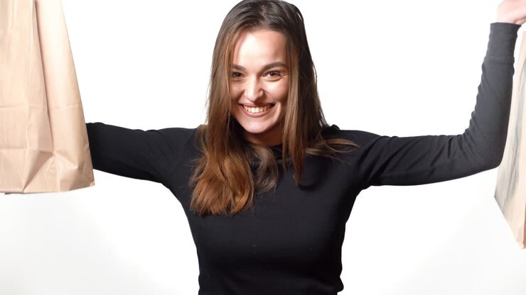 Donna felice con borse della spesa. Giovane donna con acquisti su sfondo bianco.