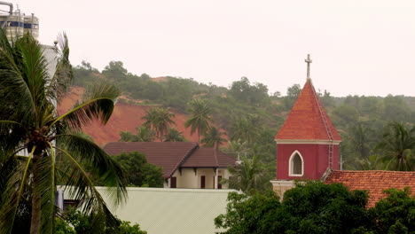 techo de la catedral de la iglesia con cruz en pueblo rural tropical, sombrío día ventoso
