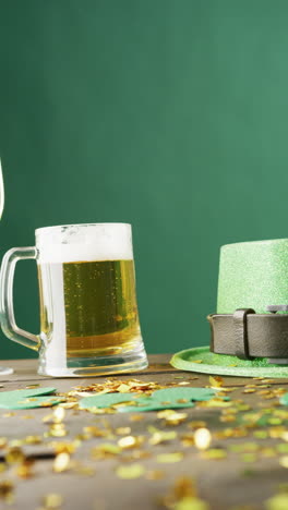 vertical video of of st patrick's green hat, beer and champagne glasses on green background