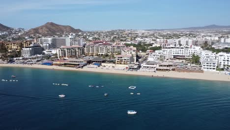 paralaje aéreo filmado frente a la costa de la hermosa playa de medano en cabo san lucas, méxico durante un viaje de verano inolvidable con playa limpia, mar azul e instalaciones turísticas de hotel