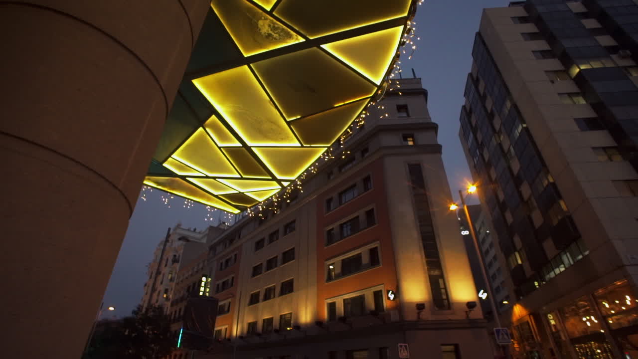Views around Madrid street life illuminated colourful mosaic entrance to building with cityscape buildings above.