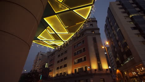 views around madrid street life illuminated colourful mosaic entrance to building with cityscape buildings above.