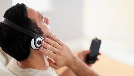 hombre disfrutando de la música en el sofá