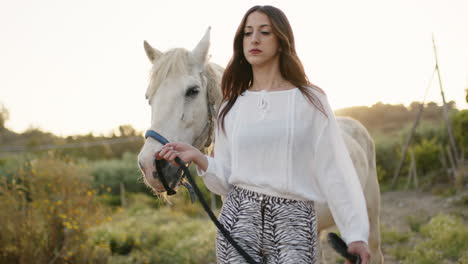 woman walking a horse in a rural setting