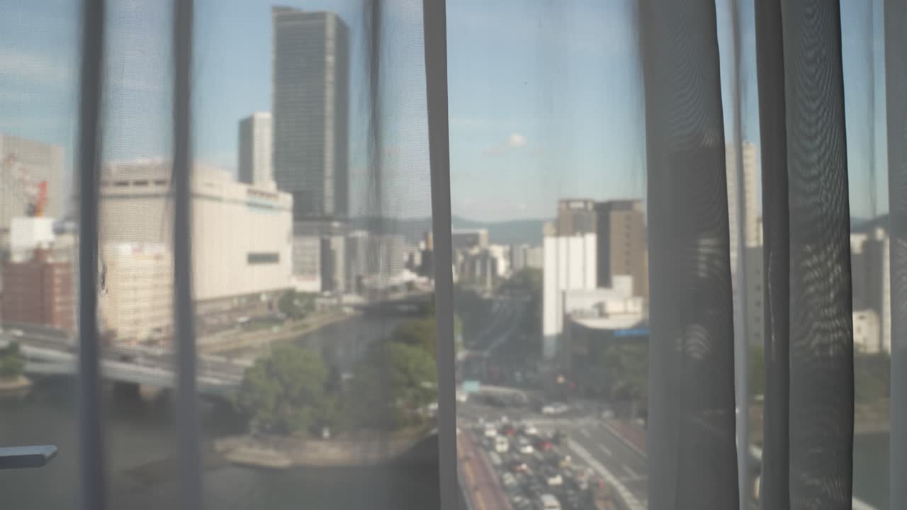 View through hotel curtains of Kyobashi Bridge and Enko River in Hiroshima, Japan