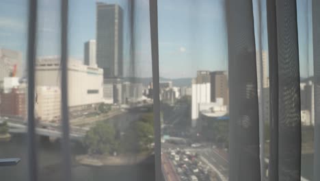 view through hotel curtains of kyobashi bridge and enko river in hiroshima, japan