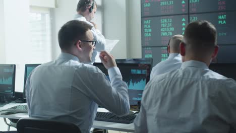 group of stockbrockers actively working at stock exchange