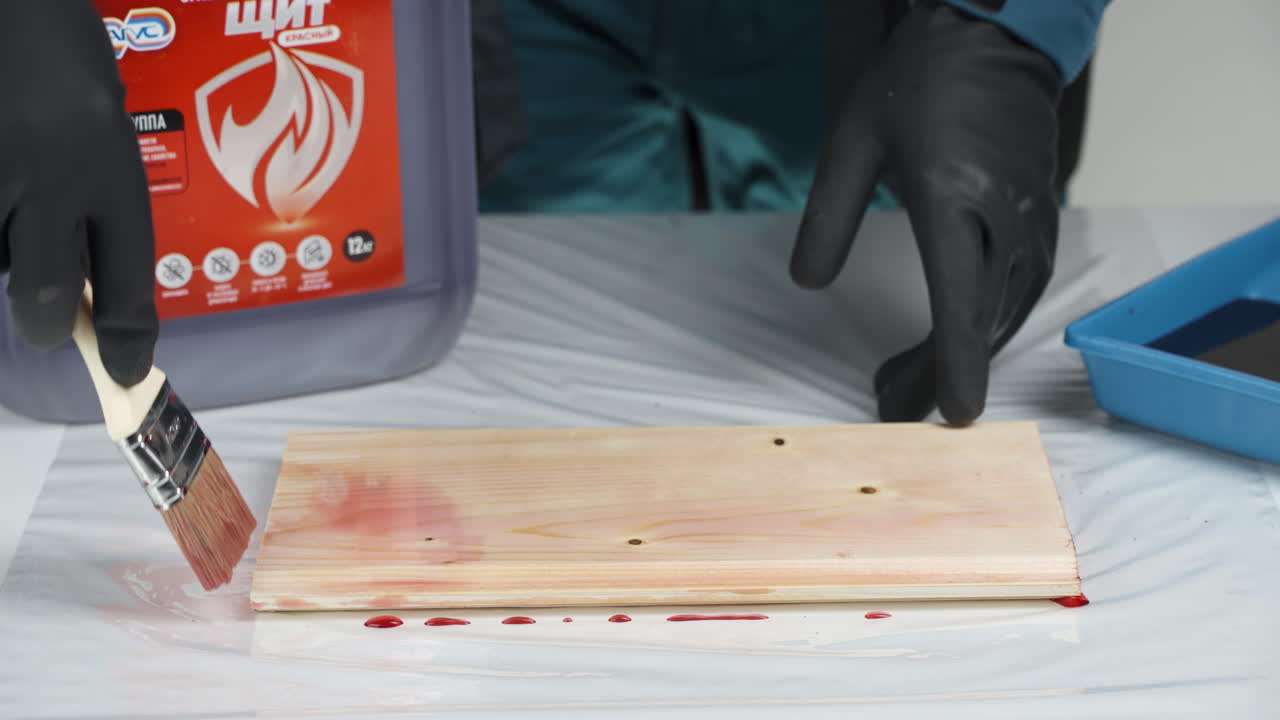 Applying Red Stain to Wood Plank