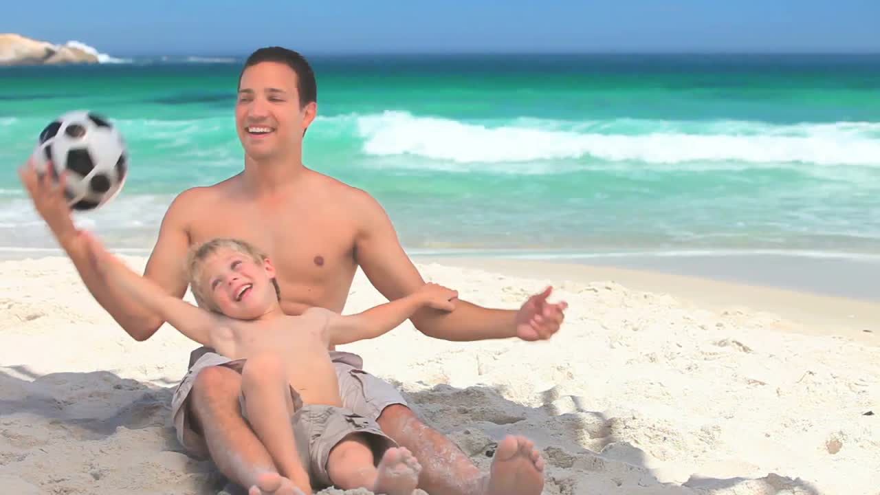 아버지 와 아들 이 축구 공 을 가지고 놀고 있다