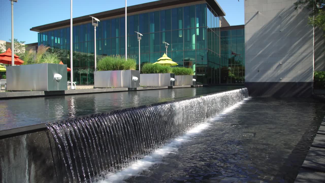 Biblioteca Pública de Whitby en Canadá con una cascada sobre un diseño arquitectónico en un día de verano.