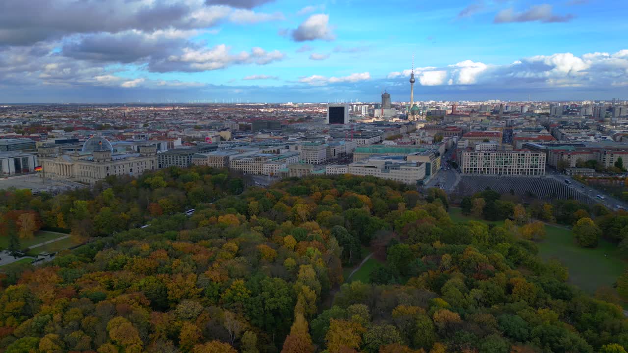 Berlin cityscape with Reichstag Building, Brandenburger Gate, Memorial to the Murdered Jews of Europe at Tiergarten in autumn. Unique aerial view flight wide orbit overview drone