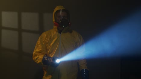 hazmat suit-wearing man explores a smoky room